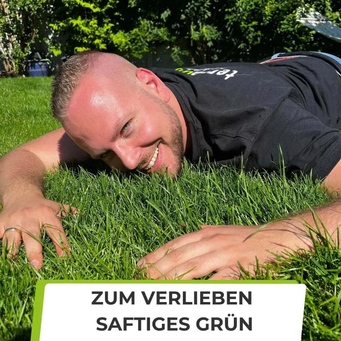 Ein lächelnder Mann liegt im saftig grünen Gras und genießt die perfekte Rasenpflege mit TerraUno Rasendünger - Sparabo. Sonnenlicht und Bäume vervollständigen die Szene. Der Text darunter lautet: ZUM VERLIEBEN SAFTIGES GRÜN.