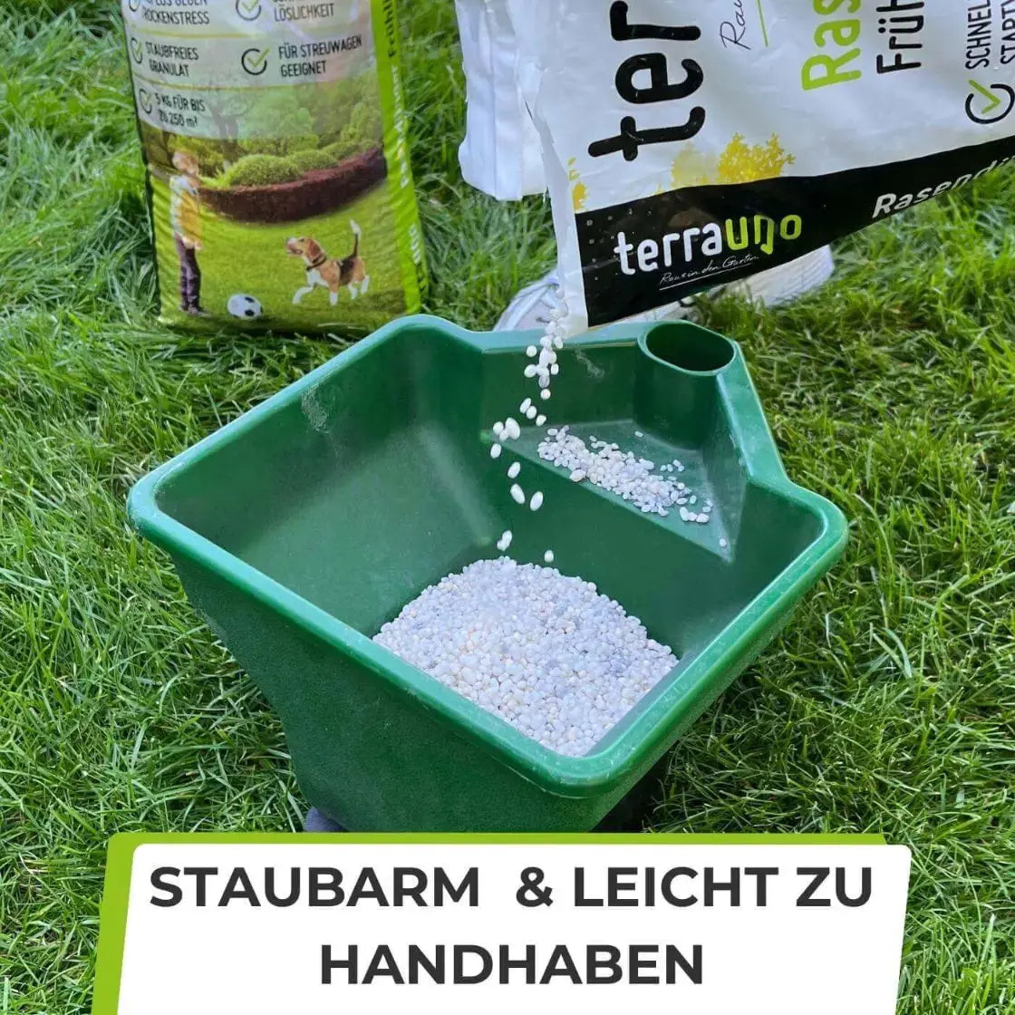 Eine Person schüttet TerraUno Rasendünger - Sparabo aus einem Beutel in eine grüne Handstreumaschine auf Gras. Der Text darunter lautet: Staubarm  leicht zu handhaben - ideal für eine mühelose Rasenpflege.
